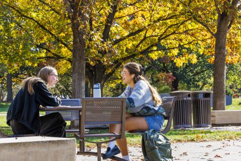 Josie Bartels (left), a junior from Lincoln, and Audrey Ellis, a sophomore from Fort Worth, Texas, laugh over the various methods of murder Bartels’ criminal justice book describes as they study outside of the Adele Coryell Hall Learning Commons.