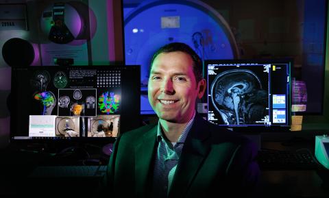 Aron Barbey is backdropped by an fMRI machine at the Center for Brain, Biology and Behavior, which he now directs after recently joining the University of Nebraska–Lincoln.